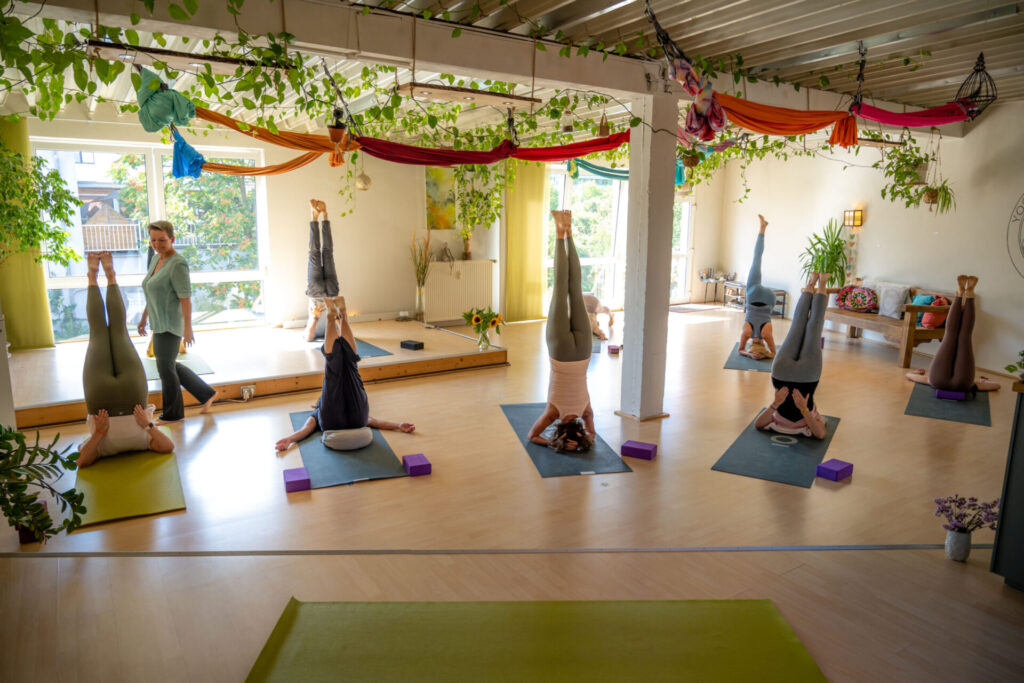 5 Frauen machen in einem Raum Kundalini Yoga